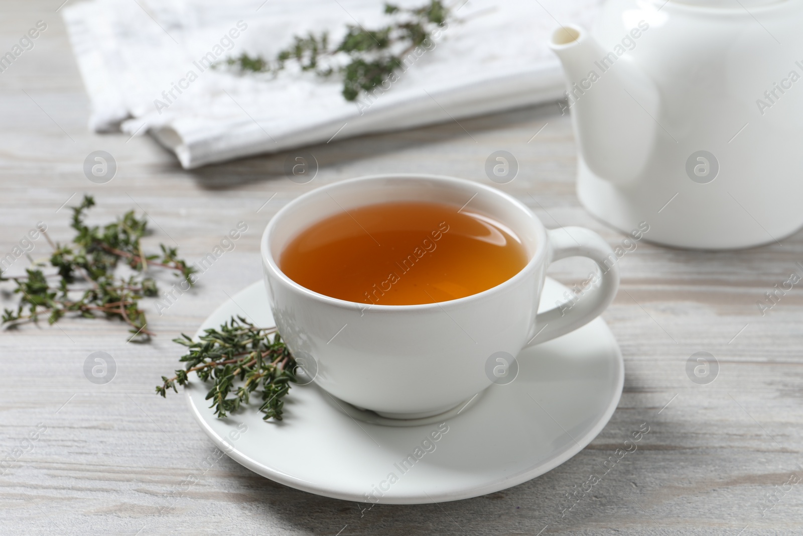 Photo of Aromatic herbal tea with thyme on white wooden table