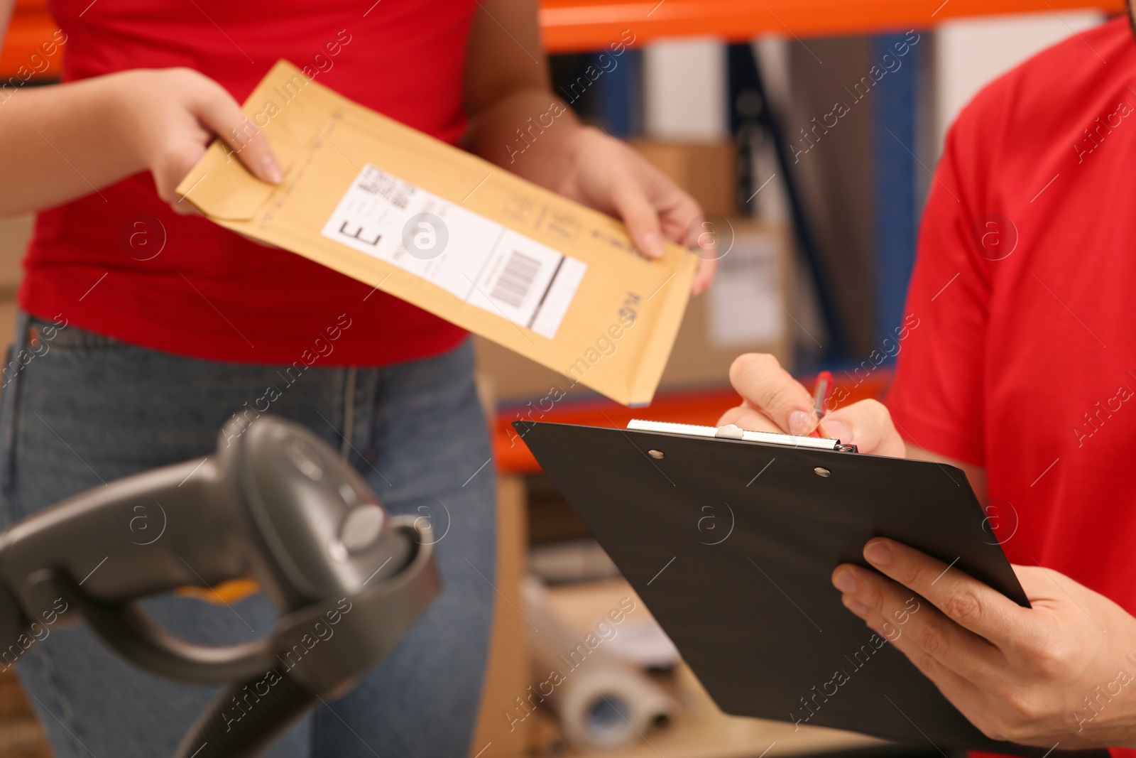 Photo of Post office workers checking parcel barcode indoors, closeup