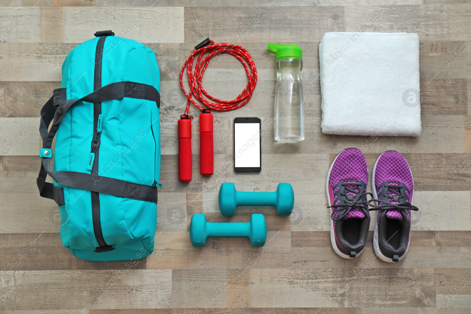 Photo of Flat lay composition with sports bag and gym equipment on wooden floor, top view