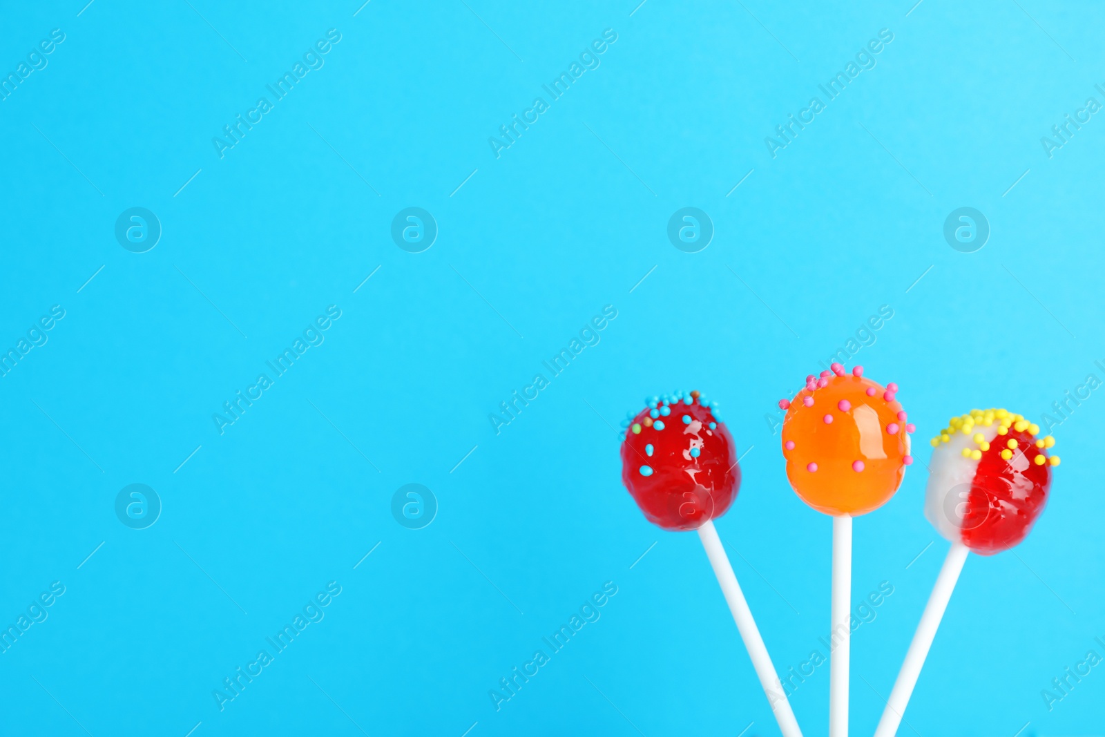 Photo of Bright yummy candies on color background. Space for text