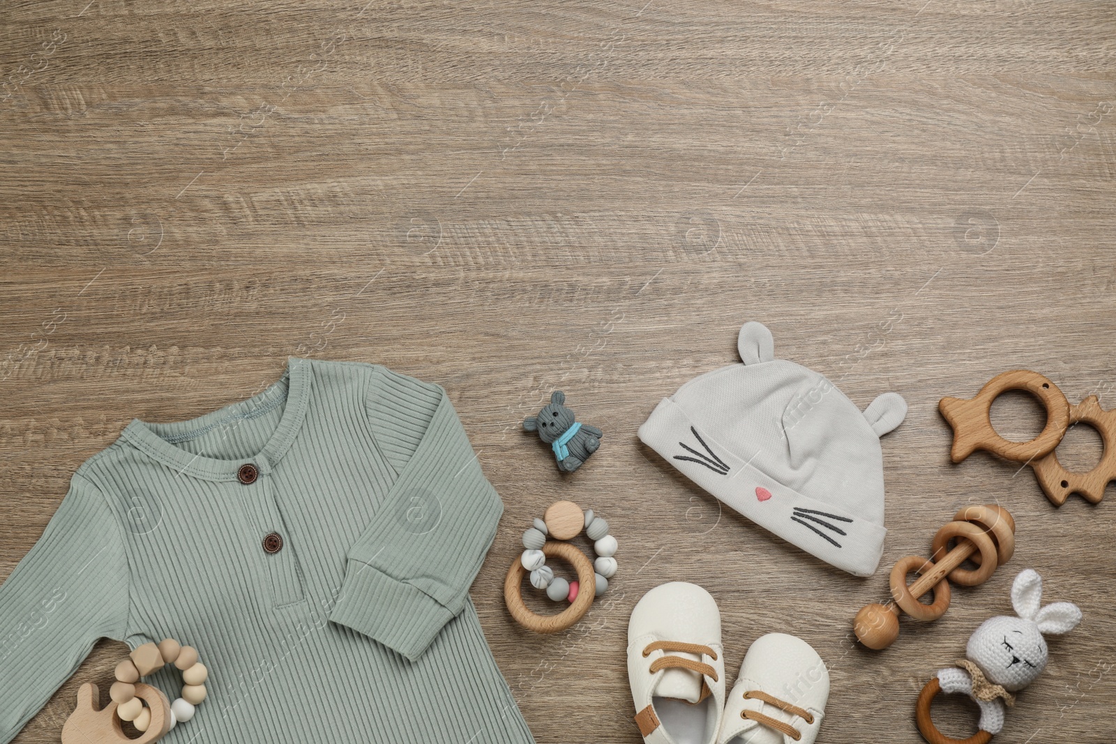 Photo of Flat lay composition with baby clothes and accessories on wooden table. Space for text