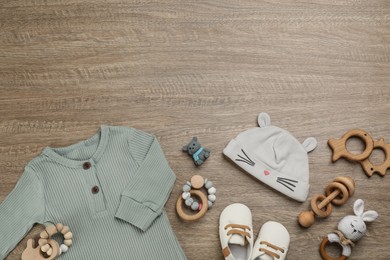 Flat lay composition with baby clothes and accessories on wooden table. Space for text