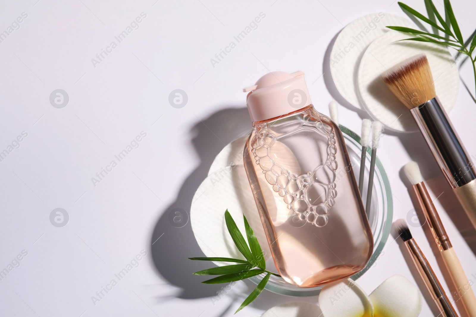 Photo of Flat lay composition with micellar water on white background. Space for text