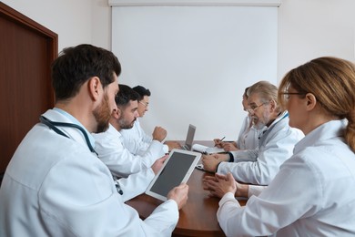 Photo of Teamdoctors having discussion during medical conference in meeting room