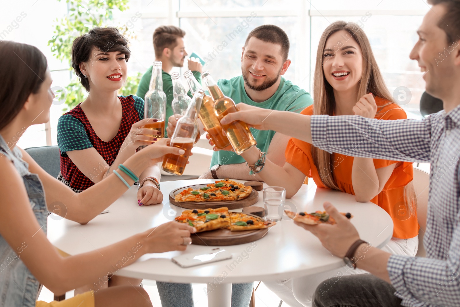 Photo of Young people having fun party with delicious pizza indoors