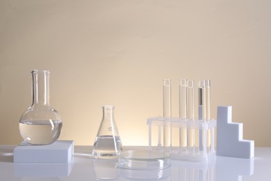 Laboratory analysis. Different glassware on table against beige background
