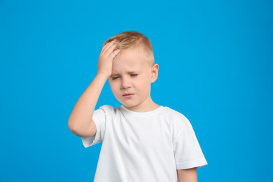 Portrait of cute little boy on light blue background