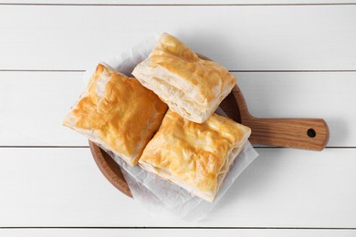 Photo of Delicious puff pastry on white wooden table, top view