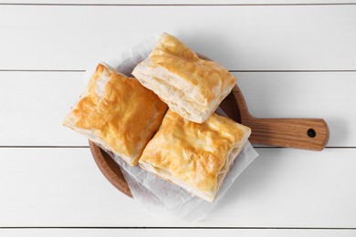 Delicious puff pastry on white wooden table, top view