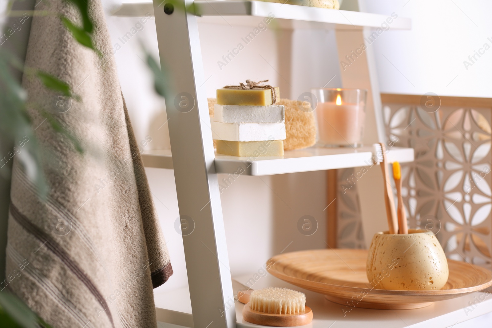 Photo of Soap and toiletries on wooden shelves in bathroom