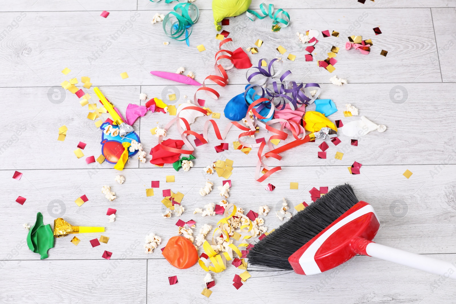 Photo of Sweeping trash after party with bristle broom indoors