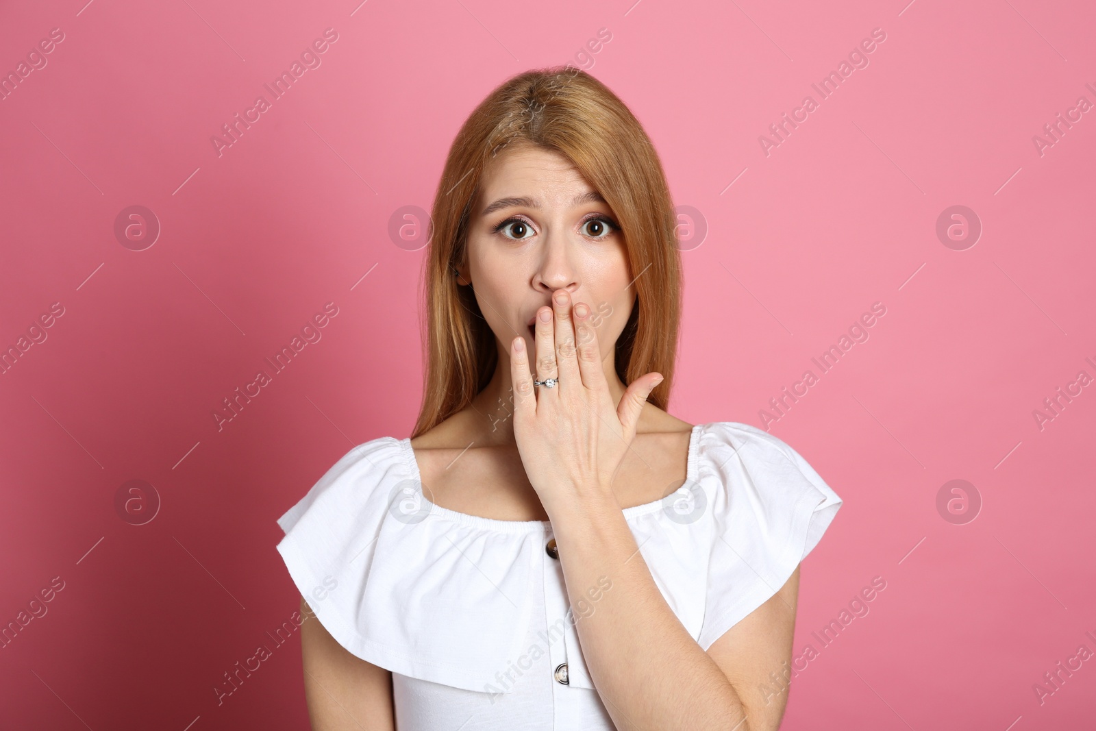 Photo of Emotional woman with engagement ring on pink background