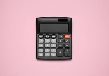 Calculator on pink background, top view. Office equipment