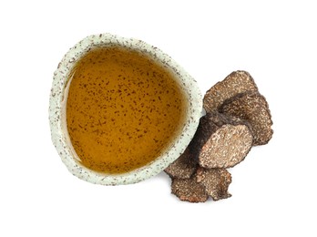 Photo of Bowl of oil and fresh truffles on white background, top view