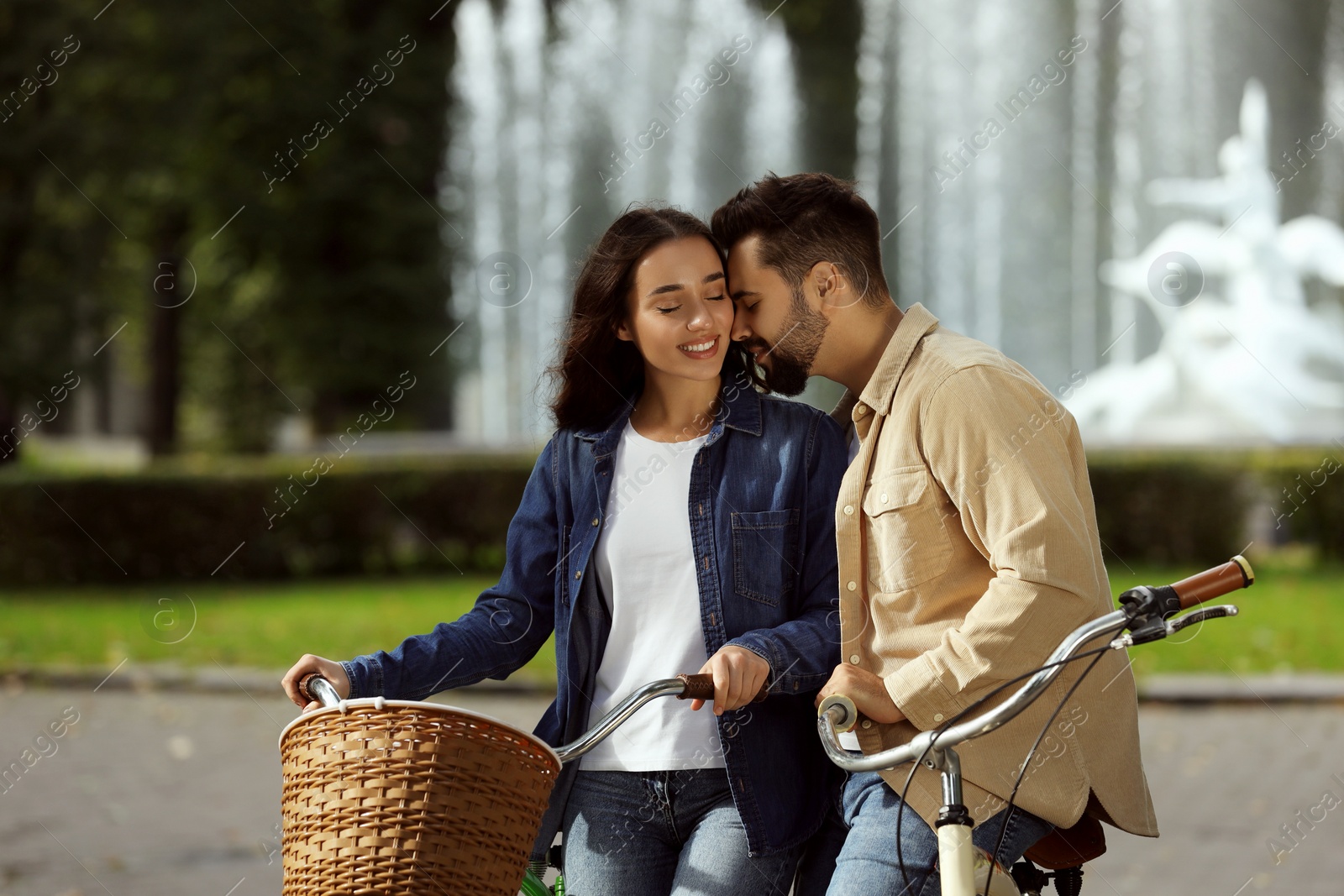 Photo of Beautiful couple with bicycles spending time together in park