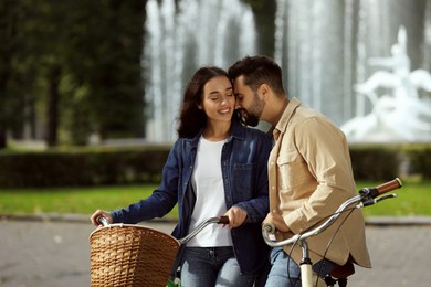 Photo of Beautiful couple with bicycles spending time together in park