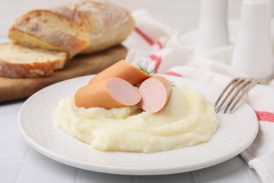 Photo of Delicious boiled sausages and mashed potato on white table, closeup