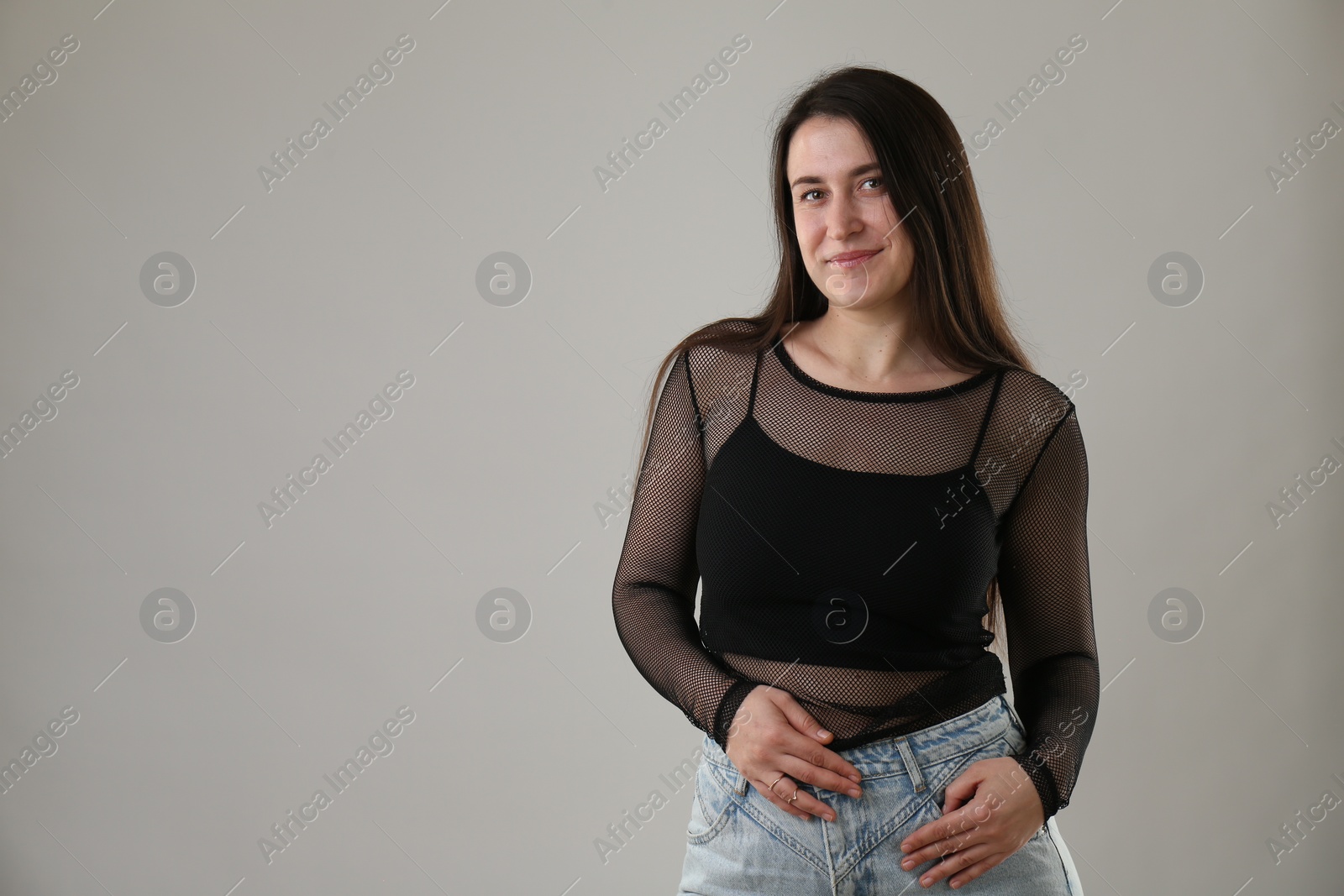 Photo of Portrait of beautiful young woman on light grey background. Space for text