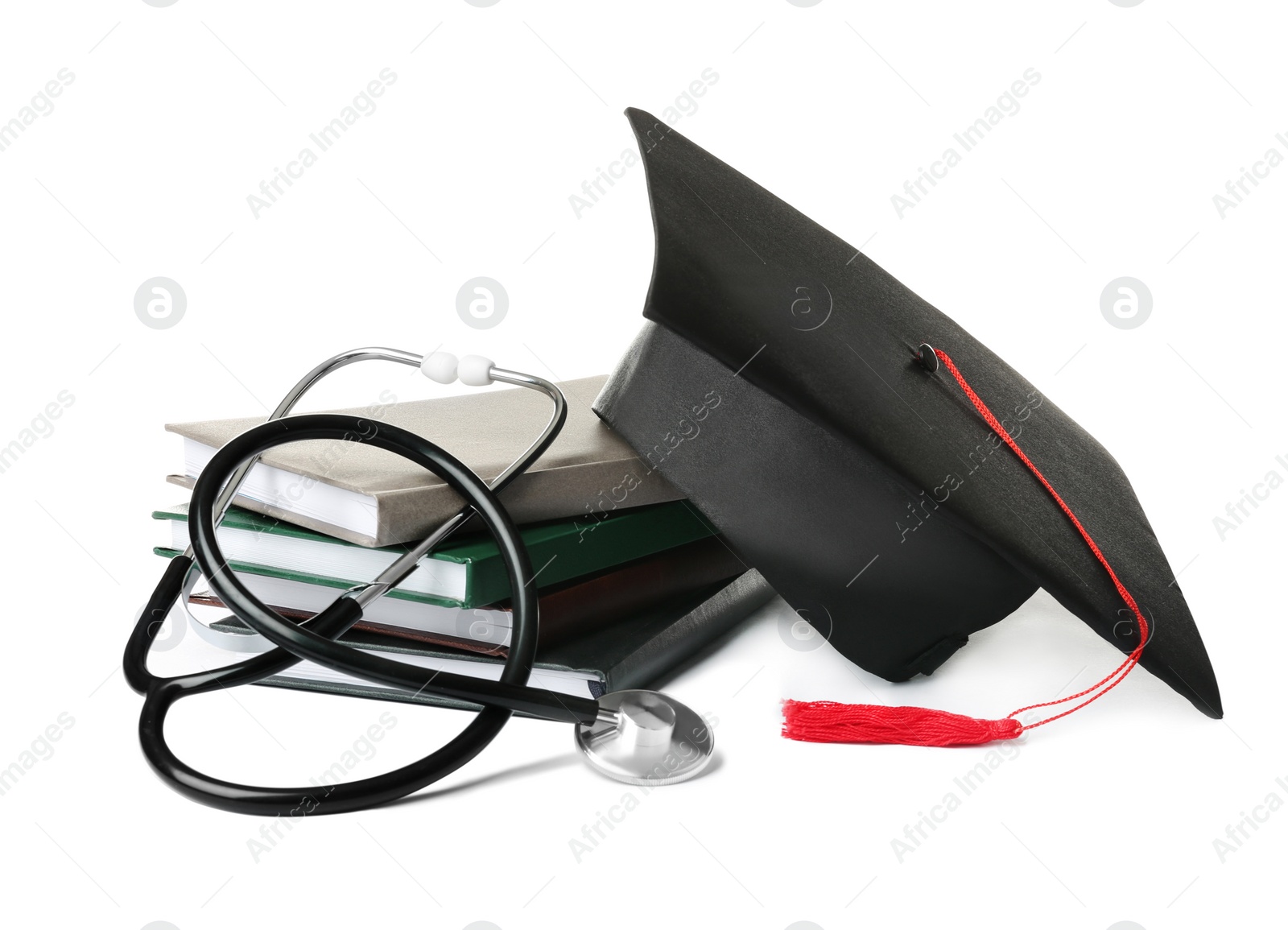 Photo of Stack of student textbooks, graduation hat and stethoscope on white background. Medical education