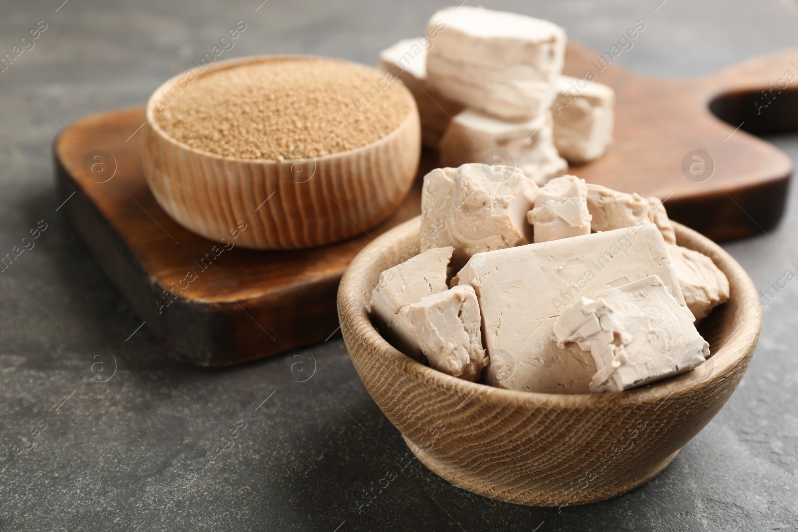 Photo of Compressed and granulated yeast on grey table