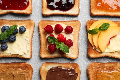 Tasty toasts with different spreads and fruits on light grey table, flat lay