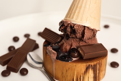 Delicious ice cream with chocolate in wafer cone served on white table, closeup