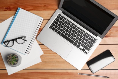 Photo of Flat lay composition with modern laptop and stationery on office table