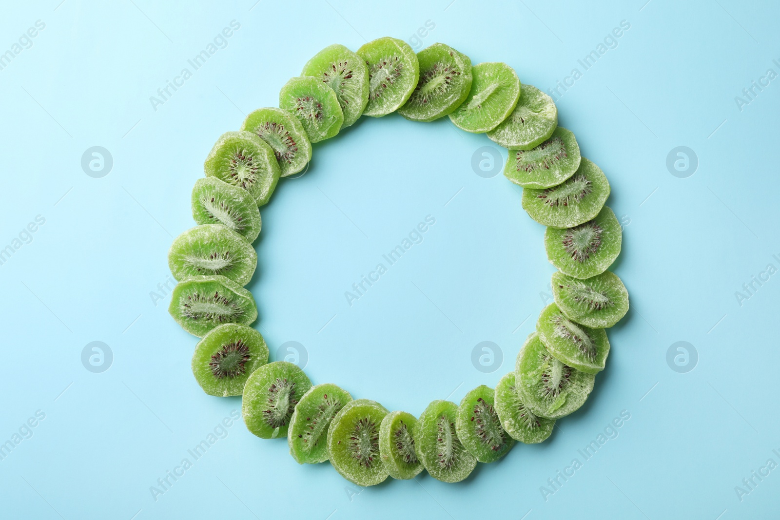 Photo of Frame made of kiwi on color background, top view with space for text. Dried fruit as healthy food