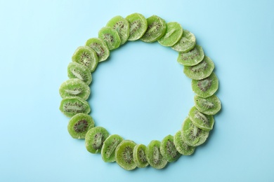 Frame made of kiwi on color background, top view with space for text. Dried fruit as healthy food