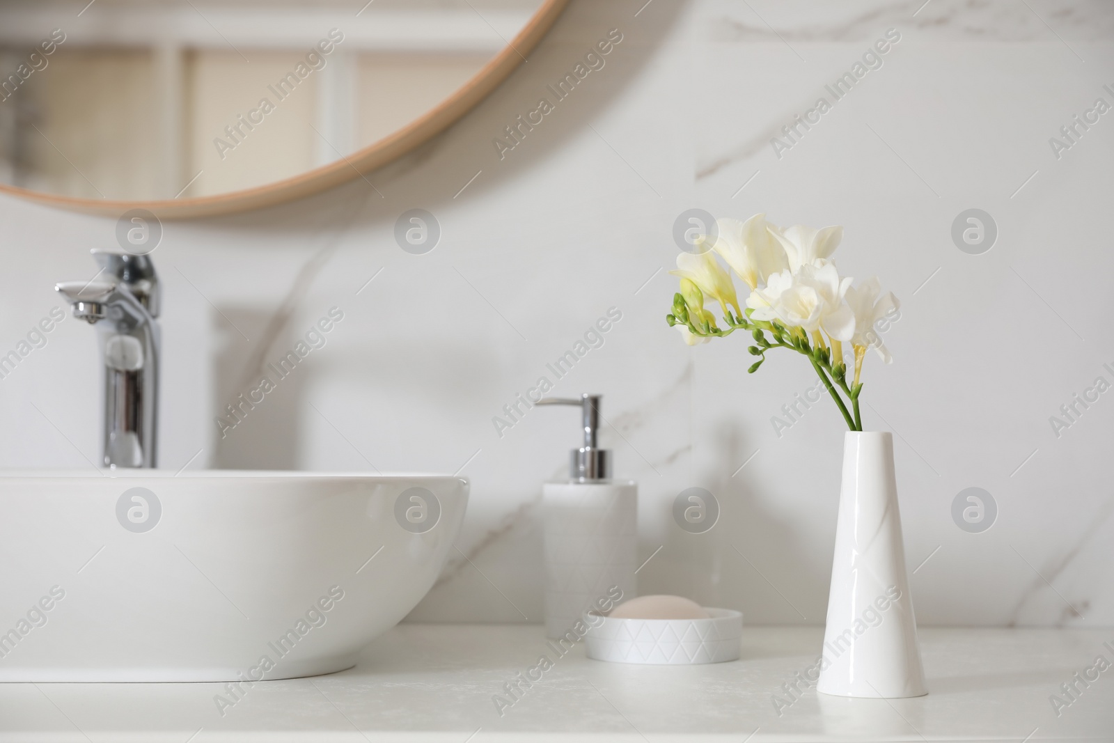 Photo of Beautiful bouquet with white freesia flowers in bathroom