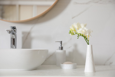 Beautiful bouquet with white freesia flowers in bathroom