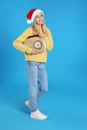 Happy woman with vintage radio on blue background. Christmas music