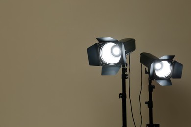 Photo of Modern spotlights against beige background, space for text