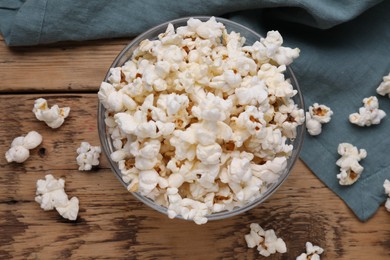 Photo of Tasty popcorn on wooden table, flat lay