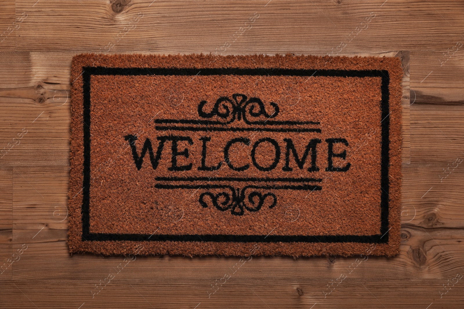 Photo of Doormat with word Welcome on wooden floor, top view