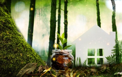 Image of Eco friendly home. House model and jar with coins in forest