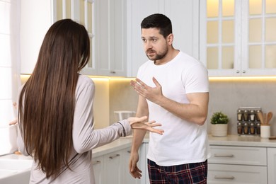 Photo of Emotional couple arguing in kitchen. Relationship problems