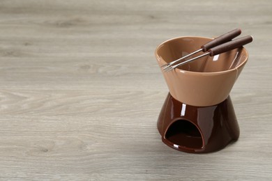 Photo of Fondue set on wooden table, space for text