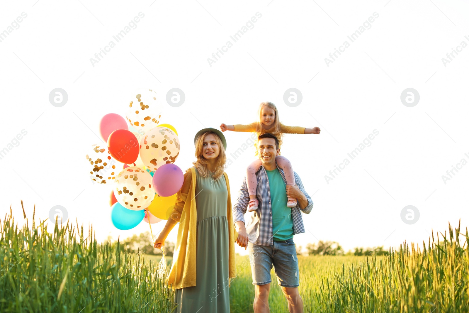 Photo of Happy family with colorful balloons outdoors on sunny day