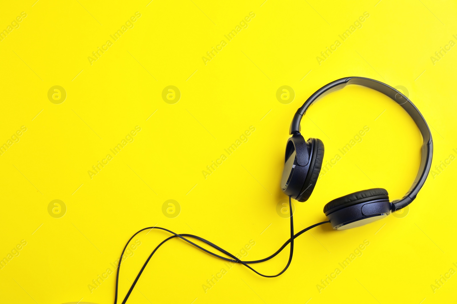 Photo of Stylish headphones on color background, top view. Space for text