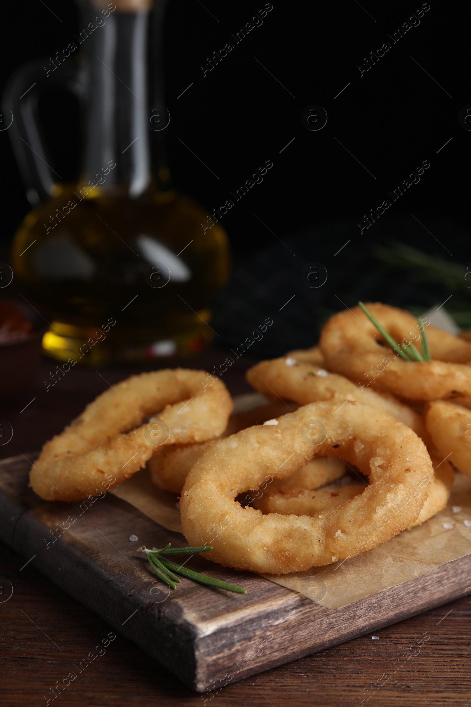 Photo of Fried onion rings served on wooden table