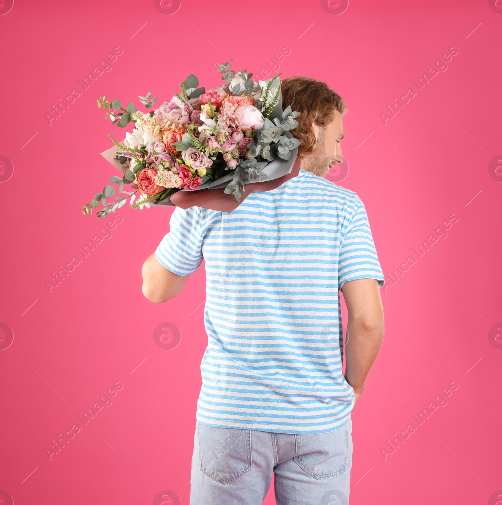 Photo of Man holding beautiful flower bouquet on pink background