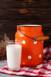 Photo of Can and glass of fresh milk on grey table