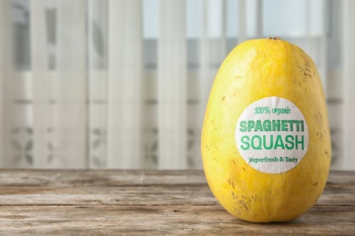 Whole ripe spaghetti squash on wooden table. Space for text