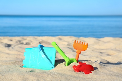 Photo of Set of plastic beach toys on sand near sea