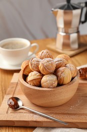 Bowl of delicious nut shaped cookies with boiled condensed milk on wooden table, closeup