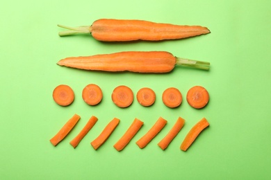 Flat lay composition with fresh sliced carrots on color background