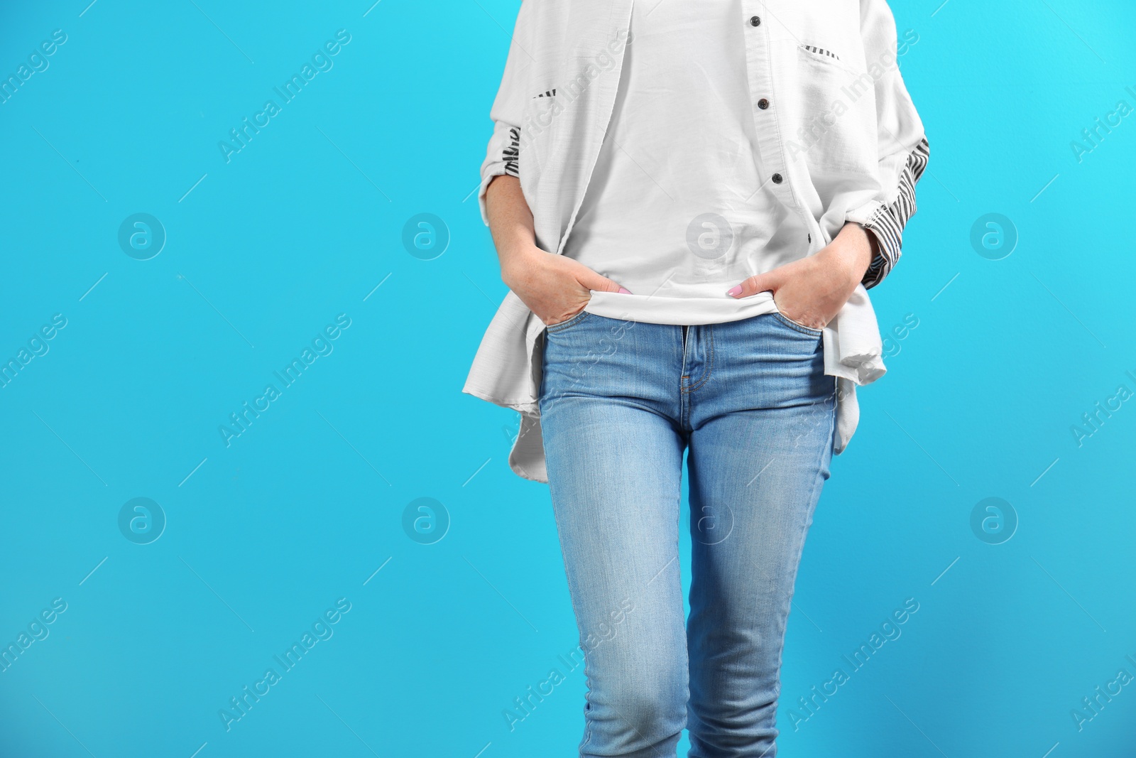 Photo of Young woman in stylish jeans on color background