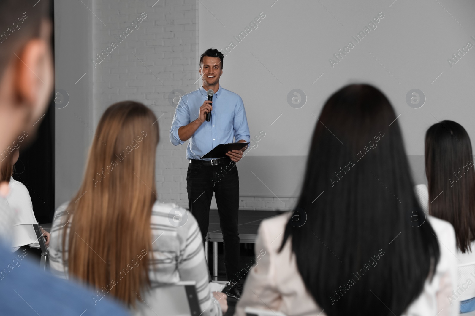 Photo of Male business trainer giving lecture in conference room with projection screen