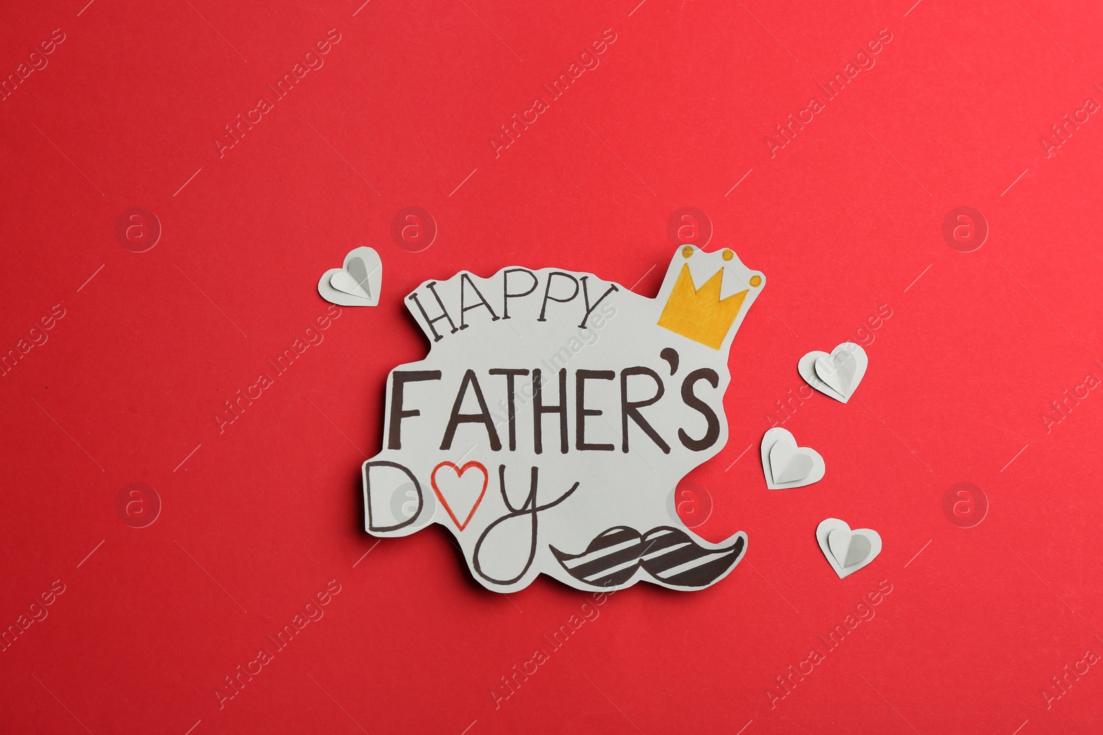Photo of Greeting card with phrase HAPPY FATHER'S DAY on red background, flat lay